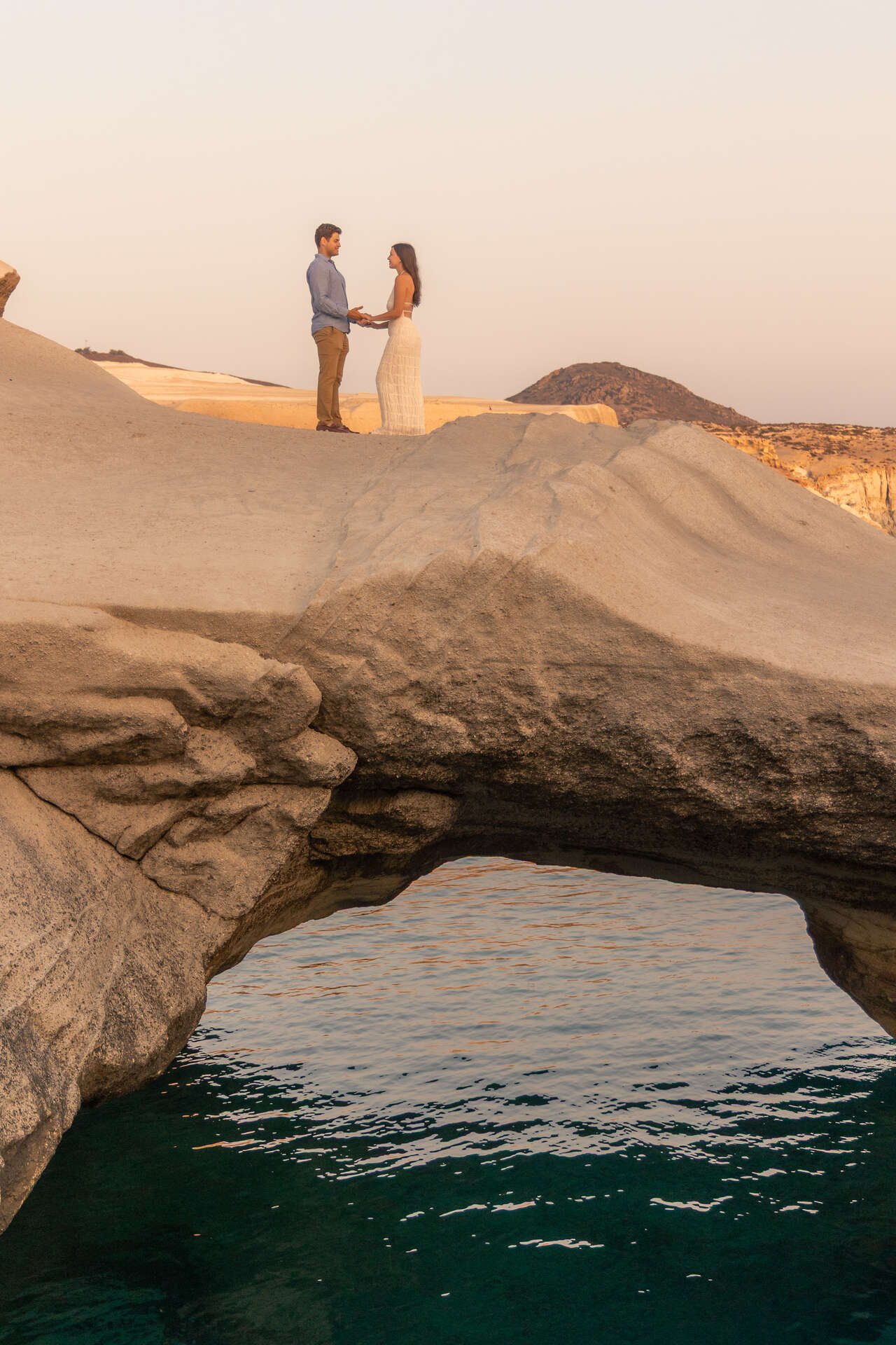 Couple on the cliffs of Milos at golden hour