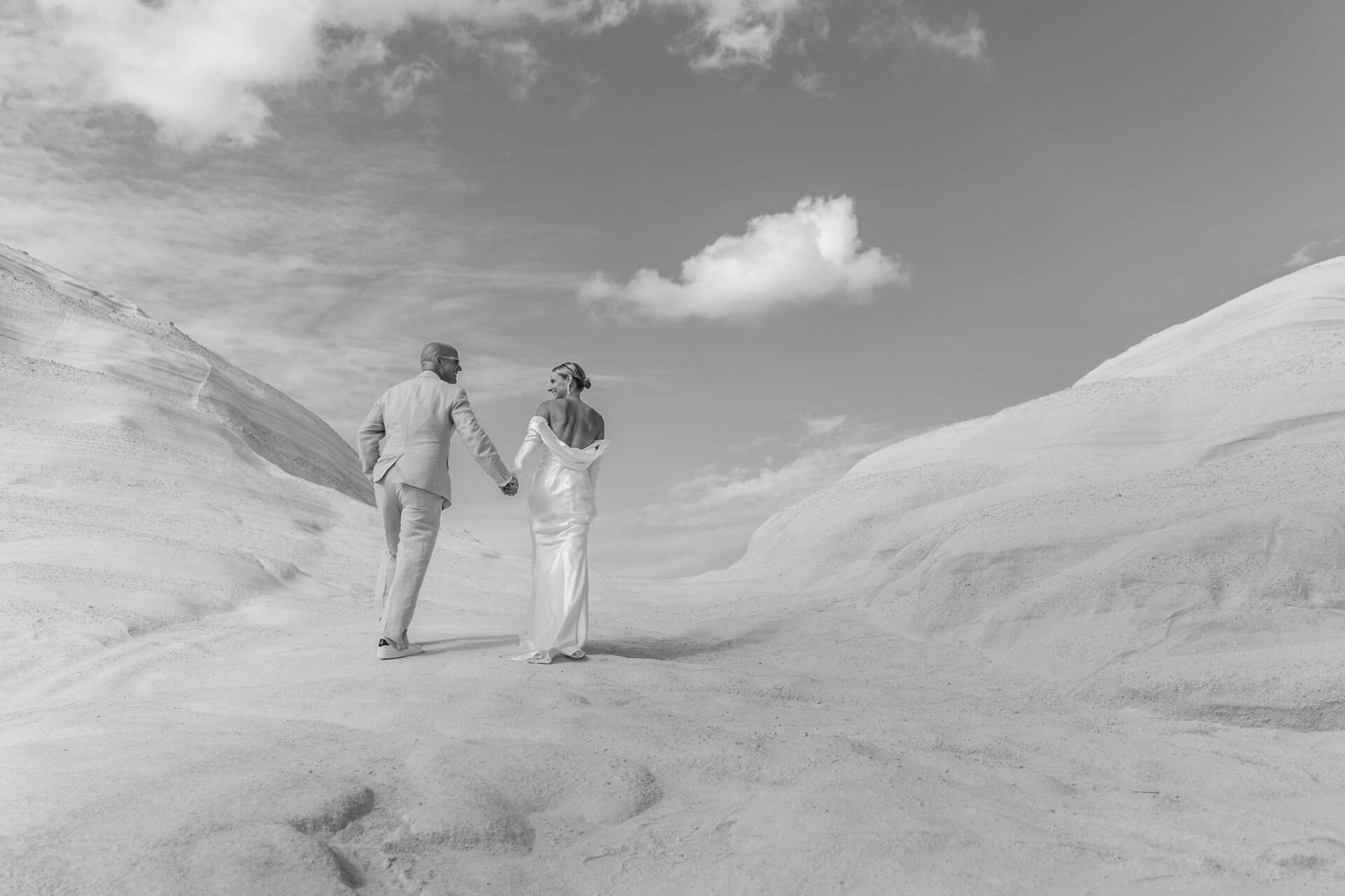 Couple at their wedding reception as the sun sets over Milos